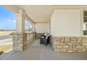 Cozy covered front porch featuring stone accents and outdoor seating at 6445 S Telluride St, Aurora, CO 80016