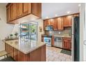 Well-lit kitchen with wood cabinets, granite countertops, stainless steel appliances, and a breakfast bar at 1200 N Humboldt St # 101, Denver, CO 80218