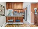 Stylish kitchen featuring wood cabinetry, a breakfast bar, stainless steel appliances, and tile flooring at 1200 N Humboldt St # 101, Denver, CO 80218
