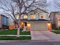 Inviting two-story home with landscape lighting and a well-manicured lawn at dusk at 5394 S Gray St, Littleton, CO 80123