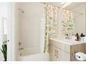 Bathroom featuring a shower-tub combination, vanity, decorative mirror, and floral shower curtain at 8711 E Hampden Ave # 26, Denver, CO 80231