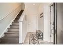 Bright entryway featuring wood stairs, a tiled floor, coat hooks, and a bench at 8711 E Hampden Ave # 26, Denver, CO 80231
