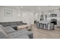 Open-concept living area with modern gray sofa, wood floors, and ample natural light at 18233 E 51St Ave, Denver, CO 80249
