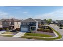 An aerial shot of a gray and blue two-story home with fenced backyard in a residential neighborhood at 902 William Way, Brighton, CO 80603