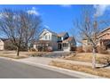 Traditional two-story home featuring meticulous lawn landscaping, a covered front porch, and a paved driveway at 15715 Carob Cir, Parker, CO 80134