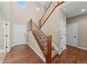 Grand foyer showcasing a hardwood floor, carpeted staircase with wooden handrail and metal spindles, and a high ceiling at 15715 Carob Cir, Parker, CO 80134