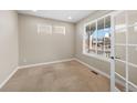 Office with a neutral carpet, white walls, and multiple windows, featuring large blinds and a glass paneled door at 15715 Carob Cir, Parker, CO 80134