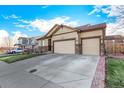 Beautiful home with a three-car garage, stone accents, and a well-maintained yard on a sunny day at 13015 Tamarac Pl, Thornton, CO 80602