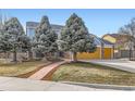 Charming two-story home featuring a tidy lawn, mature trees, and a stone facade, enhancing its curb appeal at 4027 Hawthorne Cir, Longmont, CO 80503