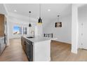 Open concept kitchen with a large island, modern pendant lighting, and stainless steel appliances at 14241 Currant, Broomfield, CO 80020
