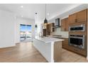 Bright, open kitchen featuring quartz counters, stainless appliances, and wood cabinets at 14241 Currant, Broomfield, CO 80020