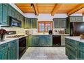 Vintage kitchen featuring teal cabinets, white countertops, tile flooring, and modern appliances at 1772 E Timber Meadow Ct, Franktown, CO 80116
