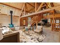 Open living room featuring log walls, wood beams, a fireplace, and comfortable seating at 1772 E Timber Meadow Ct, Franktown, CO 80116