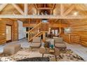 Bright living room with vaulted ceilings, exposed beams, and a staircase leading to the second floor at 1772 E Timber Meadow Ct, Franktown, CO 80116