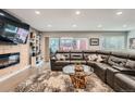 Bright living room featuring a large leather sectional, fireplace, and sliding glass doors to the backyard at 1025 Zang St, Golden, CO 80401