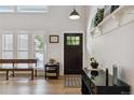 Bright entryway with white walls, hardwood floors, and stylish furniture pieces at 7440 Quail St, Arvada, CO 80005