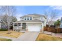 Well-manicured two-story home with a covered porch, two-car garage, and low-maintenance landscaping at 4221 Pioneer Pl, Brighton, CO 80601