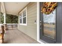 Inviting covered porch with decorative wreath on front door, offering a cozy entryway at 4221 Pioneer Pl, Brighton, CO 80601