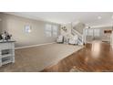 Spacious living room with ample natural light, neutral carpet, and staircase leading to the upper level at 4221 Pioneer Pl, Brighton, CO 80601