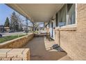 Welcoming covered porch with ample seating and a view of the neighborhood street at 3094 S Hobart Way, Denver, CO 80227