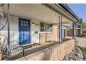 Inviting covered front porch with chair and brick accent wall, perfect for relaxing at 3094 S Hobart Way, Denver, CO 80227