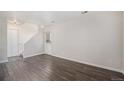 Bright living room with wood-look floors, white walls, and a staircase leading to the upper level at 1403 Valentia St, Denver, CO 80220
