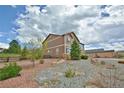 A spacious backyard with a gravel pathway, natural landscaping, and a wood fence at 735 Woodmoor Acres Dr, Monument, CO 80132