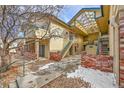 Exterior view of a multi-unit dwelling featuring brick facade, stairs, walkway and a partial pergola covered exterior hallway at 8747 E Dry Creek Rd # 1623, Englewood, CO 80112