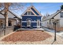Charming blue home featuring a well-manicured front yard with outdoor seating and a welcoming facade at 1144 S Logan St, Denver, CO 80210