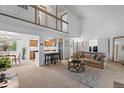Bright living room with vaulted ceilings, loft, and open-concept design to dining and kitchen at 7507 Braun St, Arvada, CO 80005