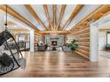 Spacious living room with exposed beams, a stone fireplace, and hardwood floors at 1651 Pine Valley Rd, Evergreen, CO 80439