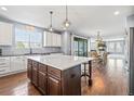 Open concept kitchen features a large island, granite countertops, and seamless access to the dining and living areas at 11584 Pine Canyon Ln, Parker, CO 80138