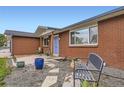 Inviting front entrance with a blue door, brick facade, and decorative landscaping at 865 S 8Th Ave, Brighton, CO 80601