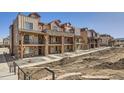 Exterior view showcasing multiple townhomes with stone accents and balconies at 9654 Browns Peak Cir, Littleton, CO 80125