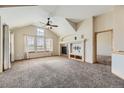 Spacious living room with vaulted ceiling, fireplace, and carpeting at 7851 S Quatar Ct, Aurora, CO 80016