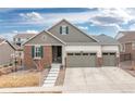 Charming single-Gathering home featuring a three-car garage and an inviting entrance with stone accents at 8234 S Vandriver Way, Aurora, CO 80016