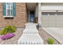 Inviting front entrance with stone accents, concrete steps, and a storm door at 8234 S Vandriver Way, Aurora, CO 80016