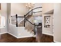 Elegant entryway featuring a grand staircase with black iron railings and hardwood floors at 10028 Chelmsford Ter, Parker, CO 80134