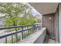 Balcony view showing the railing, brick exterior, and street with trees below at 830 N Sherman St # 208, Denver, CO 80203