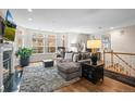 Living room with a fireplace, large windows, hardwood floors, and comfortable seating area at 30 Garfield St # B, Denver, CO 80206