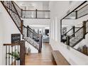 Grand foyer with hardwood floors, staircase with decorative railings, and a large decorative mirror at 117 Nova Ct, Erie, CO 80516