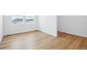 Bright bedroom with light wood floors, white walls, two windows, and ample space for customization at 16671 W 93Rd Ave, Arvada, CO 80007