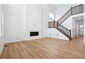 Spacious living room with hardwood floors, a modern fireplace, and an elegant staircase leading to the upper level at 16671 W 93Rd Ave, Arvada, CO 80007