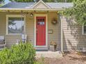 A detailed close up of the home's porch, showcasing the vibrant red front door and cozy seating at 3265 S Ogden St, Englewood, CO 80113