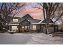 Two-story home with gray siding, three-car garage, and snowy yard at 7909 Fairfax Ct, Niwot, CO 80503