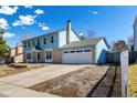 Two-story home with brick and blue siding, attached garage and driveway on a clear, sunny day at 2336 S Dawson Way, Aurora, CO 80014