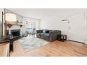 Bright living room with a stone fireplace, sliding door, and comfortable gray couch at 14141 E Jewell Ave # 101, Aurora, CO 80012