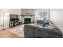 Inviting living room with a stone fireplace, TV, and cozy gray sectional sofa at 14141 E Jewell Ave # 101, Aurora, CO 80012