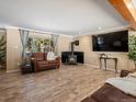 Inviting living room with wood-burning stove, large TV, and view of the natural landscape at 28268 Shadow Mountain Dr, Conifer, CO 80433