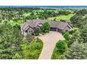 Breathtaking aerial shot showcasing lush landscaping, mature trees, and stone exterior of estate at 4725 Palmer Ridge Dr, Parker, CO 80134